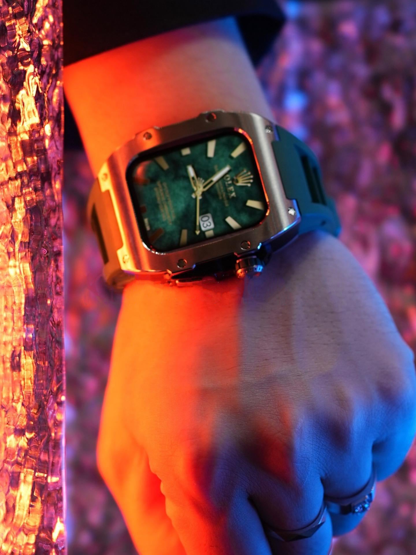 Kewusuma Titan Series - Silver Titan Titanium Apple Watch Case with a forest green watch strap worn by a man putting his hand beside a crystal light
