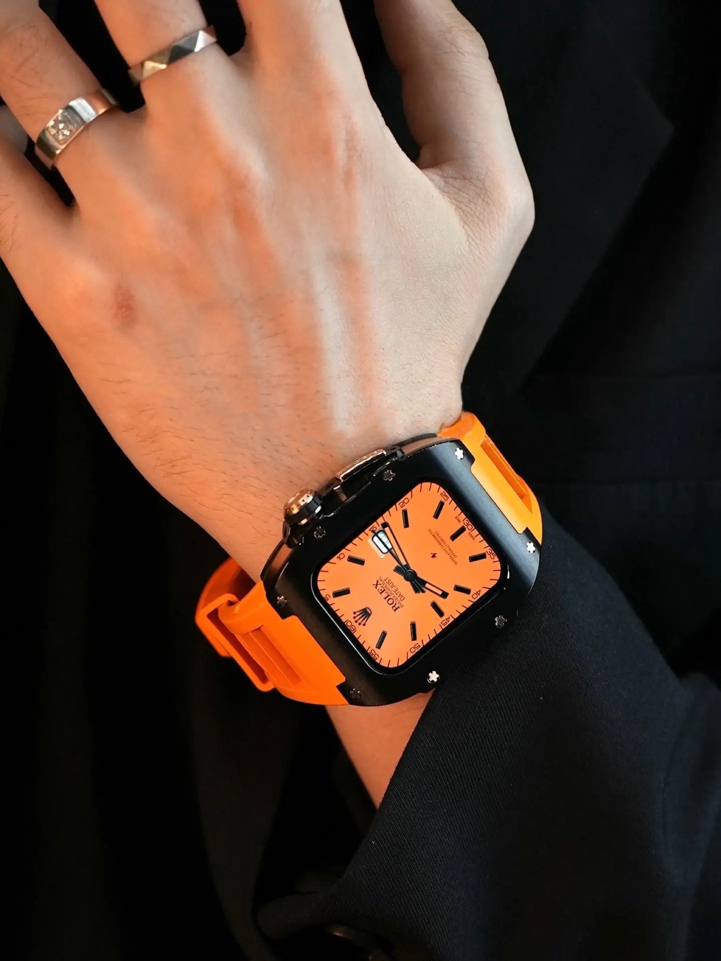 Kewusuma Titanium Black Apple Watch Case with Orange strap wore by a man with a black coat
